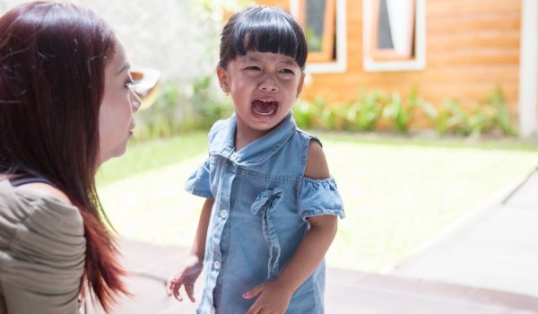Toddler crying while her mother patiently looks at her