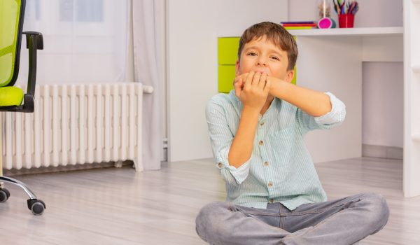 Anxious child biting his hand